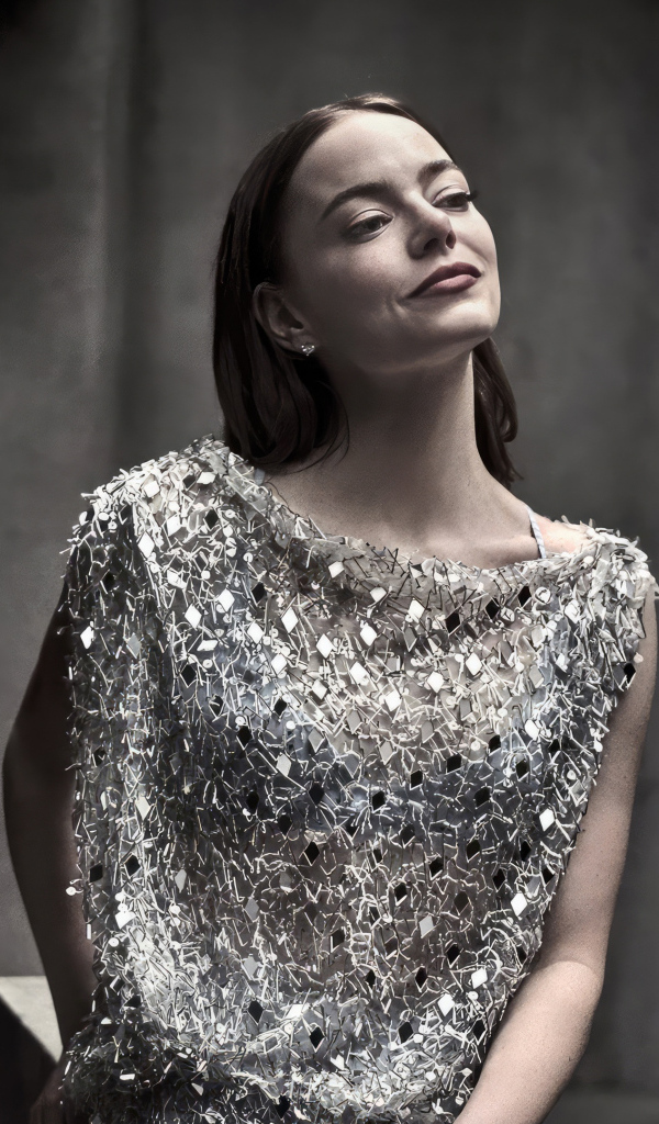 Рыжеволосая актриса Эмма Стоун в блестящем платье в серой комнате