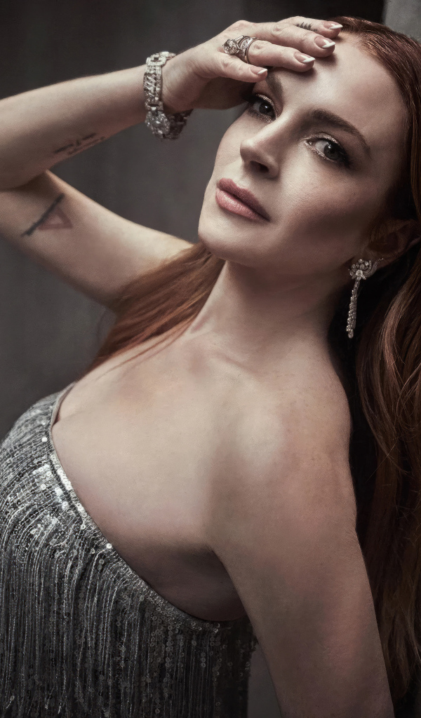 Рыжеволосая актриса Линдси Лохан стоит у стены