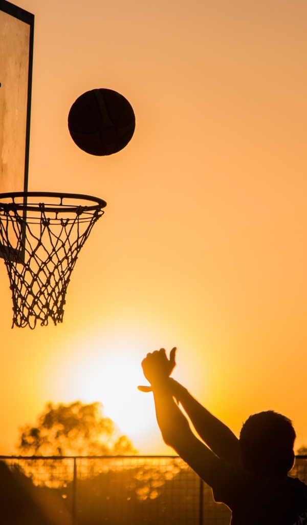 Бросок в баскетбольное кольцо на закате