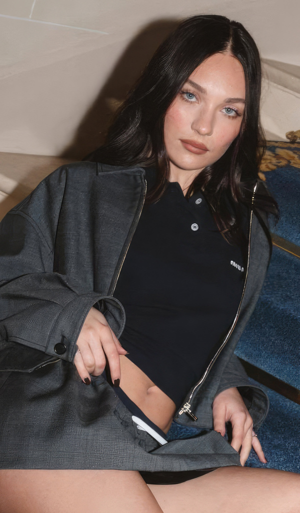 Стройная девушка актриса и танцовщица Мэдди Зиглер сидит на лестнице