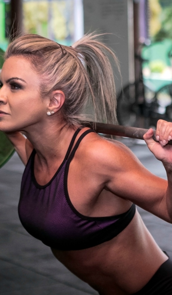 Сильная спортивная девушка поднимает штангу