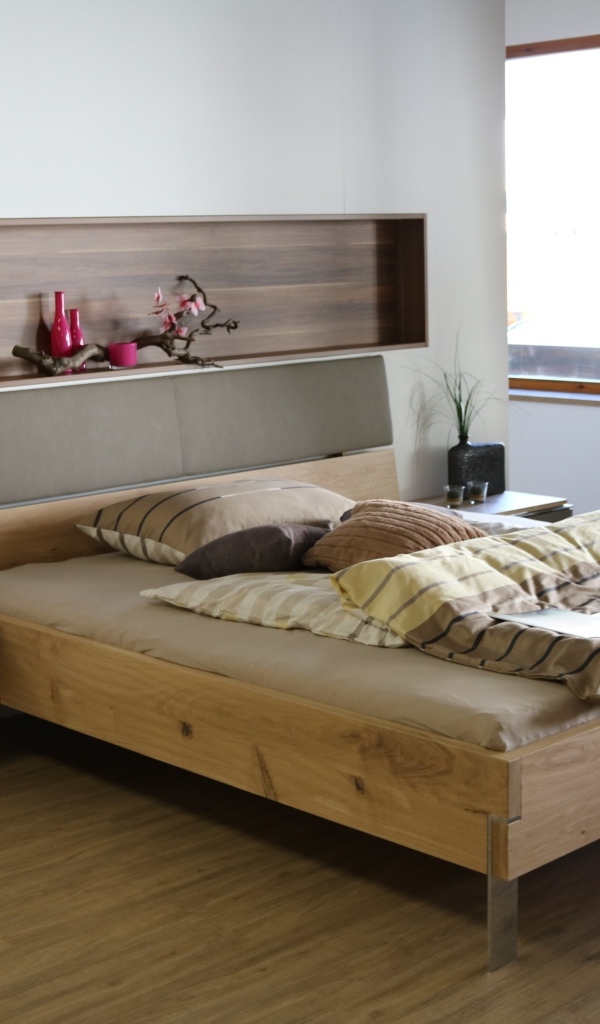 Деревянная кровать на ножках в спальне