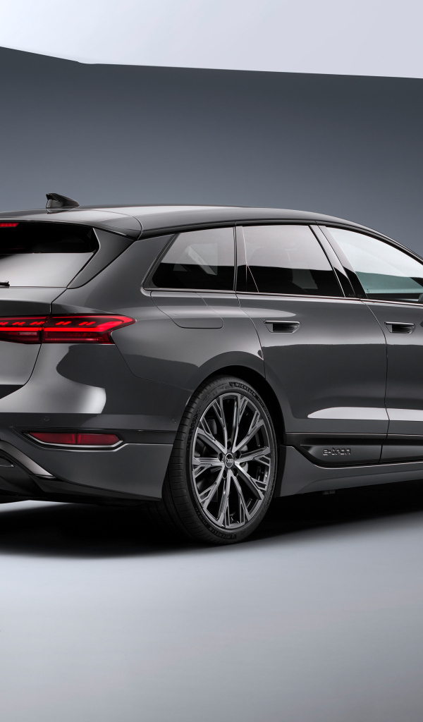 Автомобиль Audi A6 Avant e-tron S line 2024 года на сером фоне вид сзади