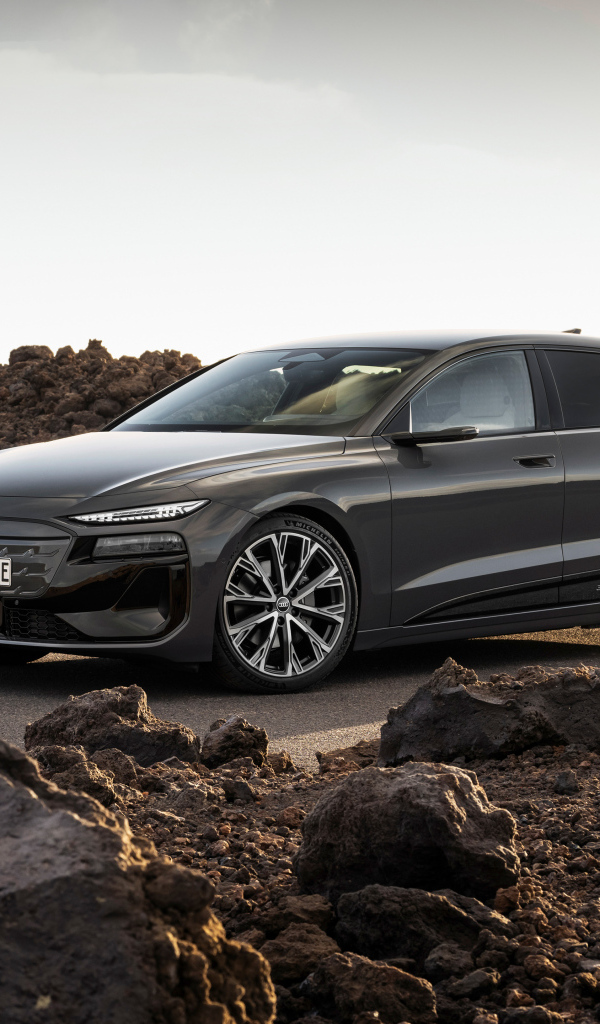 Автомобиль Audi A6 Avant e-tron S line 2024 года на дороге с камнями