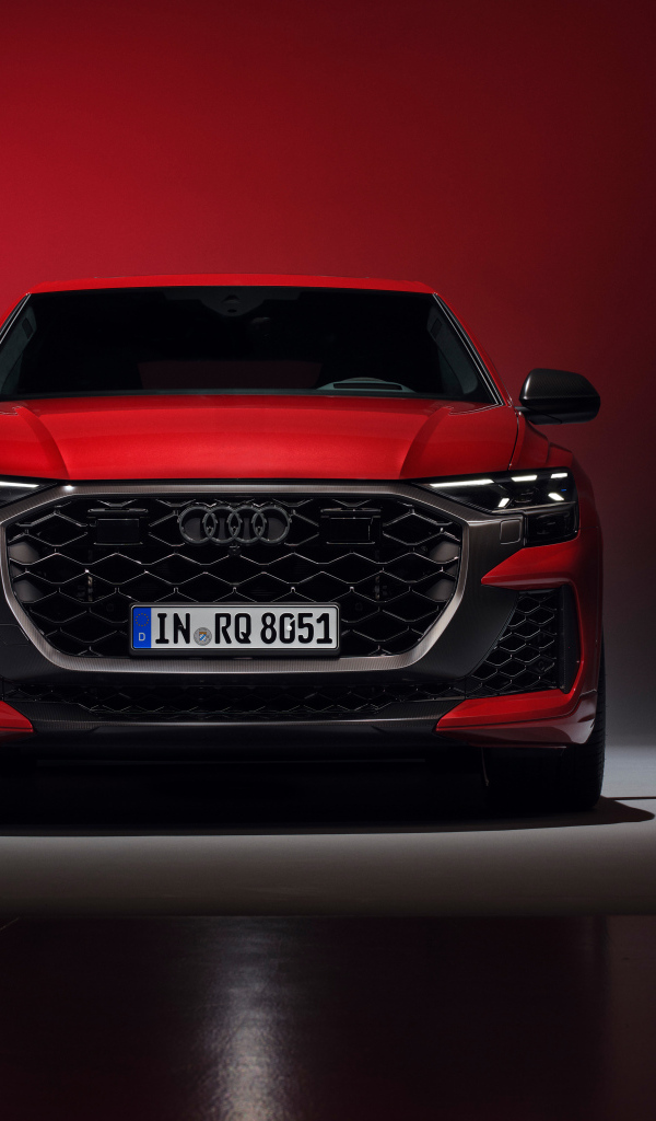 Вид спереди на автомобиль Audi RS Q8 performance 2024 года на красном фоне