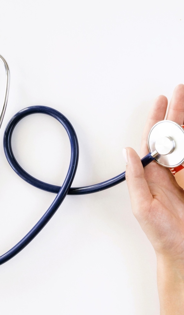 Стетоскоп слушает раненое сердце в ладонях