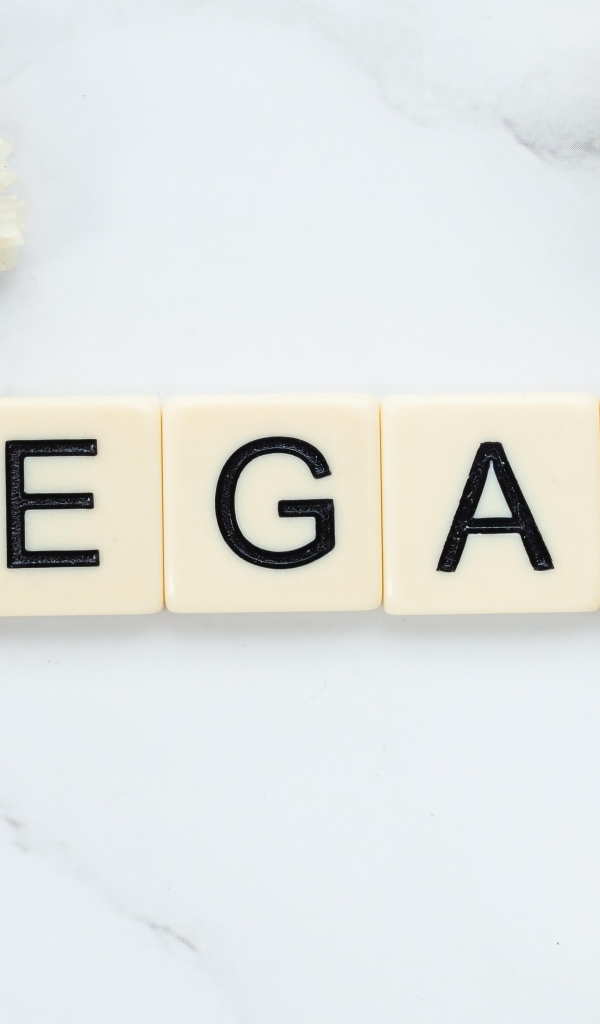 Надпись веган на столе с цветами