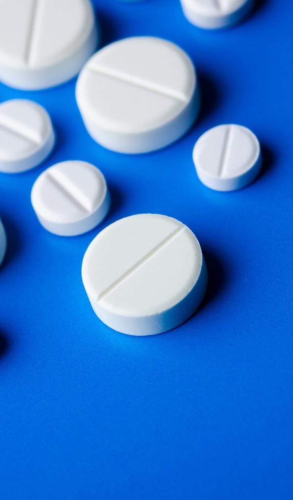Белые таблетки на синем фоне