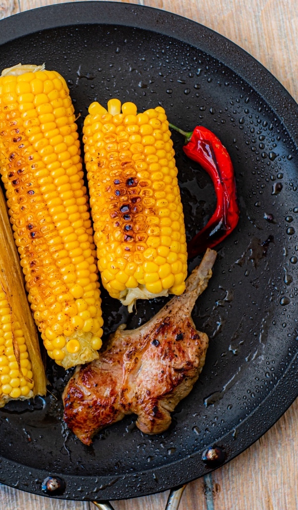 Запеченная кукуруза с ребрышками на тарелке