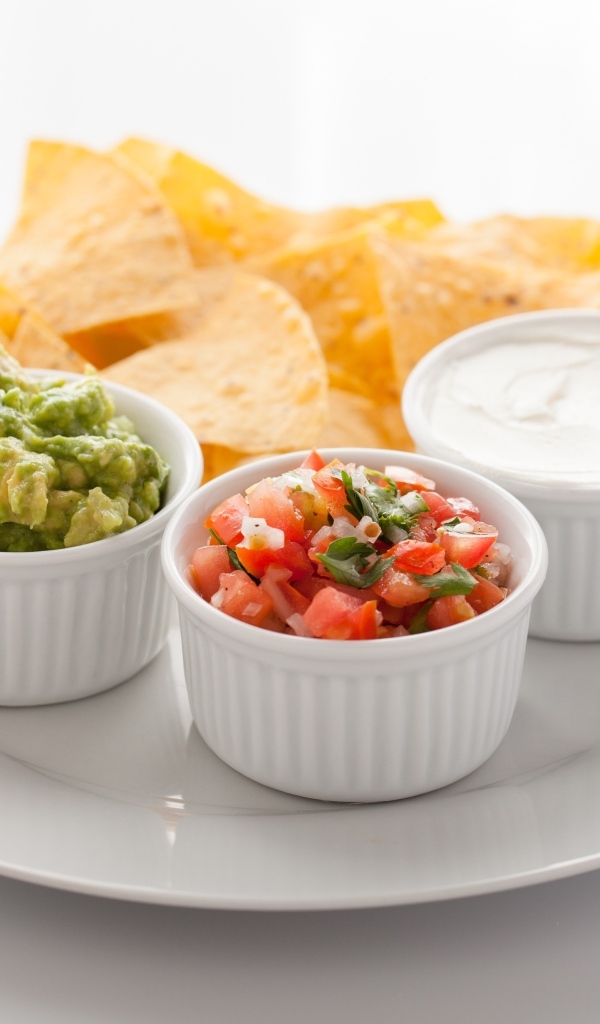 Чипсы с соусом на большой белой тарелке