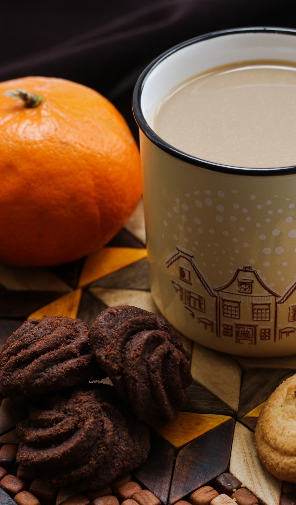 Чашка какао на тарелке с мандарином и печеньем