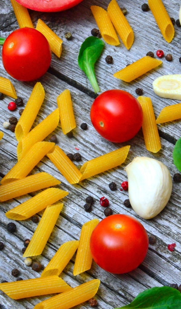 Макароны на столе с помидорами и чесноком