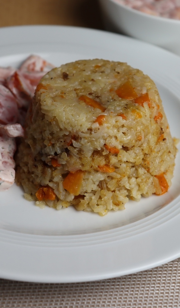 Рис с салатом на большой белой тарелке