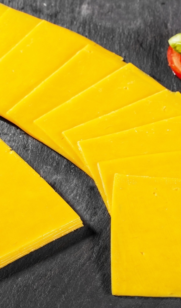 Ломтики сыра с помидором на столе