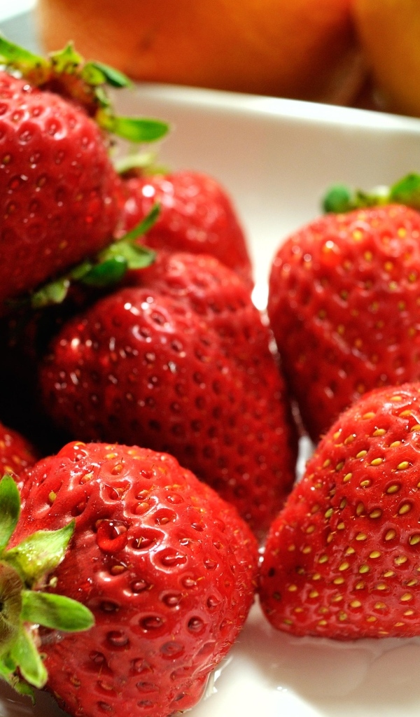 Ароматная красная клубника в белой тарелке