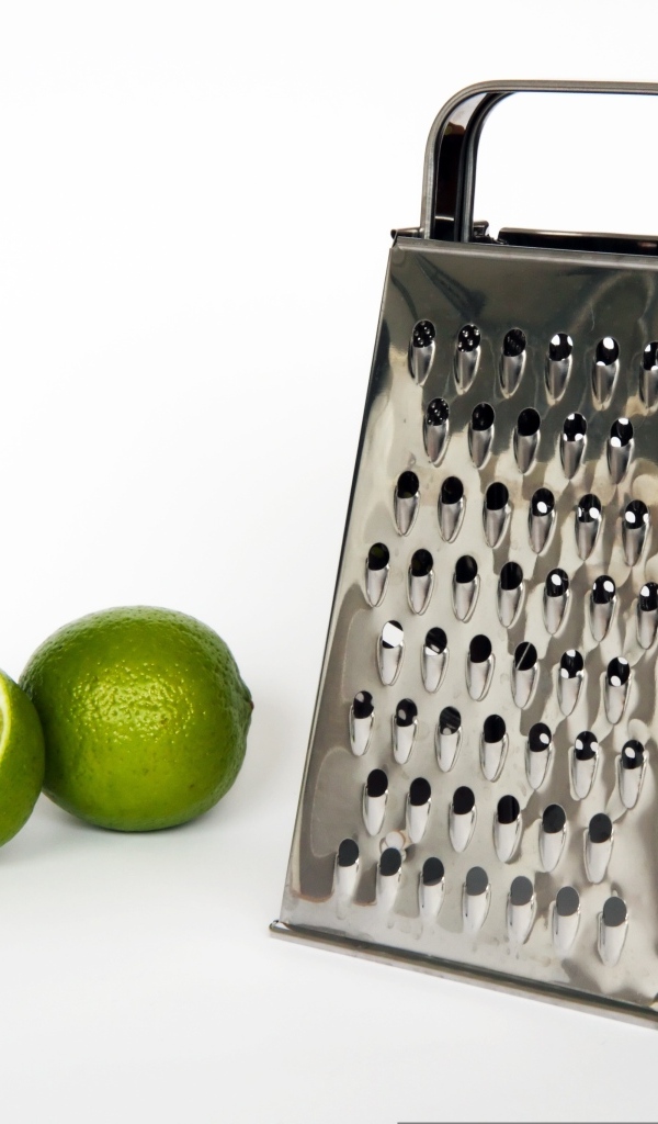 Терка с зеленым лаймом на сером фоне