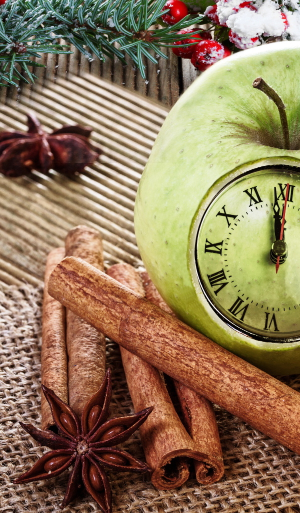 Зеленое яблоко с часами на столе со специями