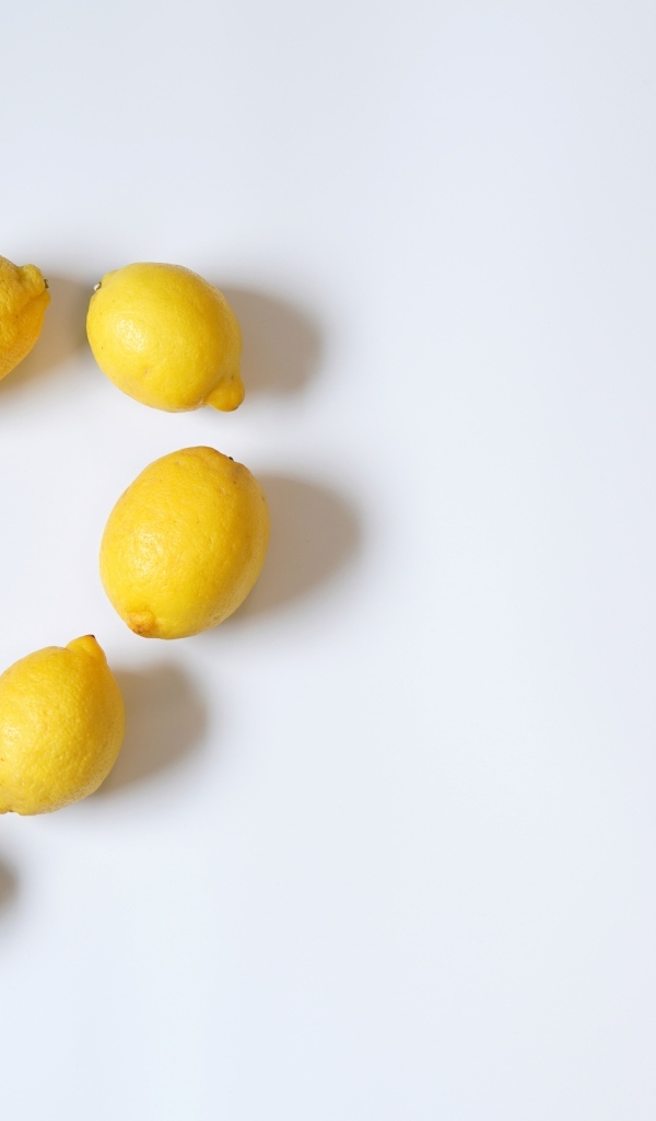 Сердце из желтых лимонов на сером фоне с конфетами