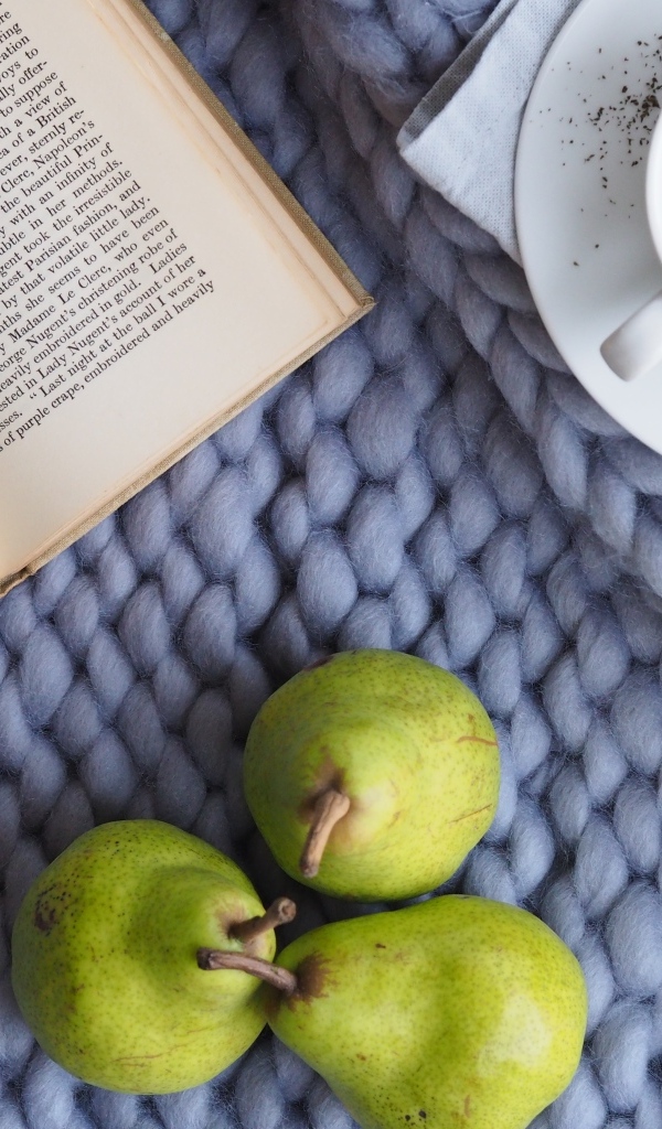 Три зеленые груши на столе с чаем и книгой