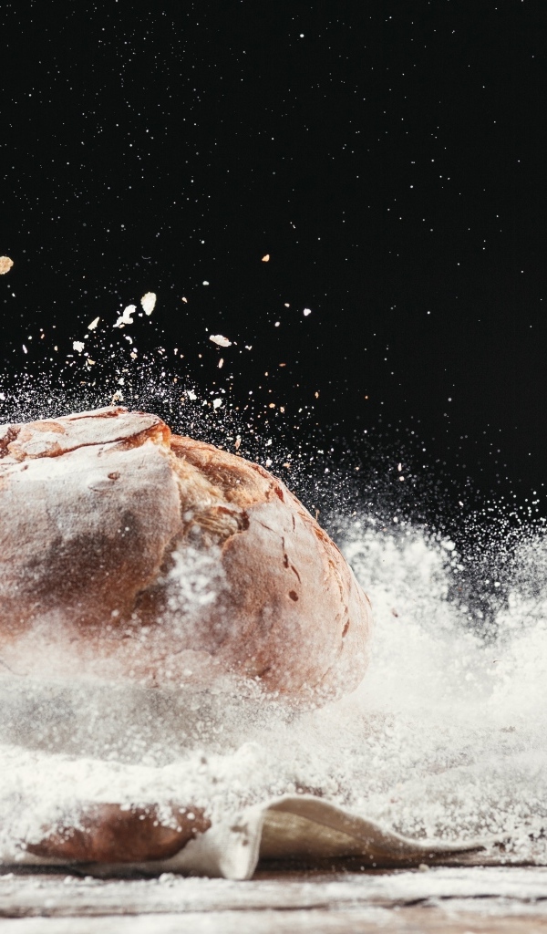 Буханка хлеба в муке на столе