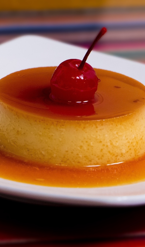 Десерт с сиропом и черешней на белой тарелке