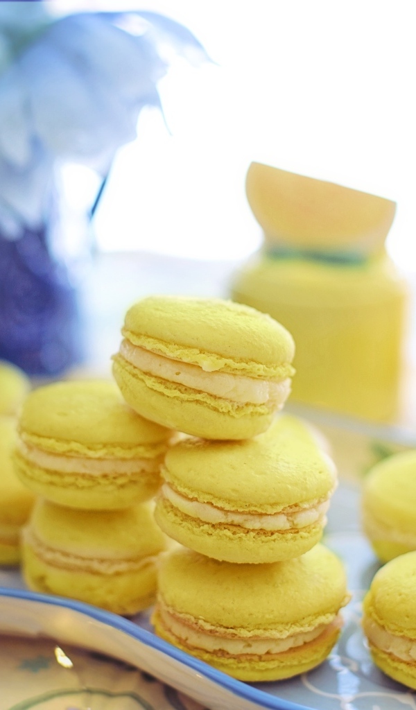 Десерт макарунс желтого цвета на тарелке на столе