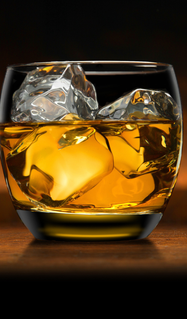 Стакан виски со льдом на столе