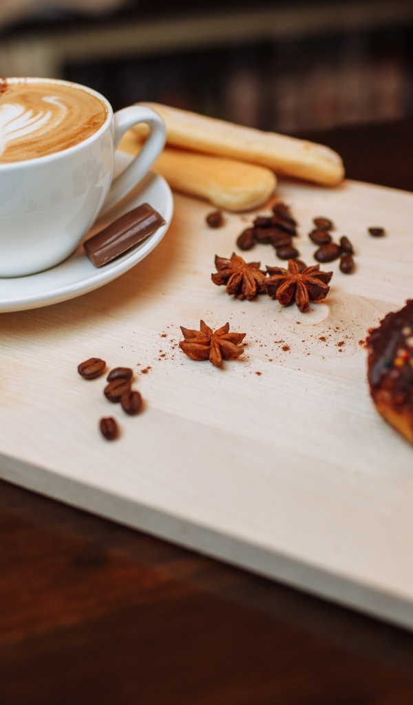 Чашка кофе на доске со специями и печеньем