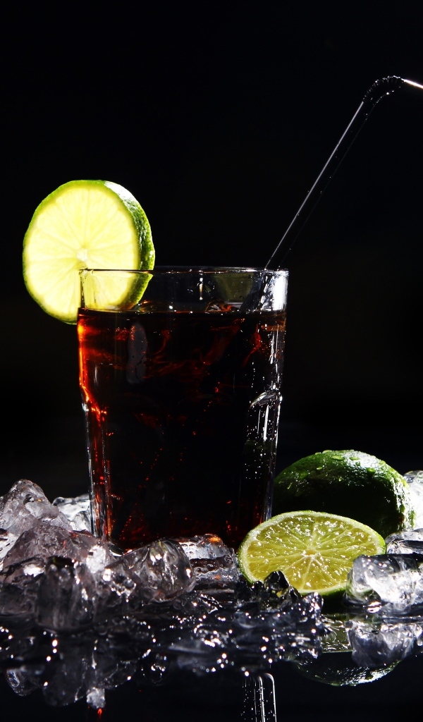 Стакан колы со льдом на черном фоне с кусочками лимона