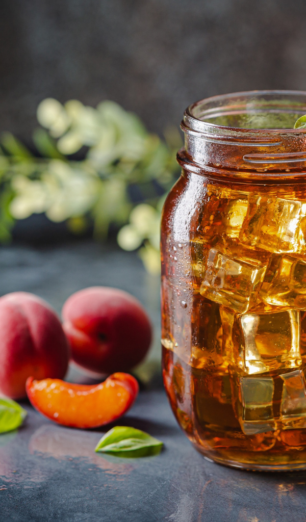 Холодный чай со льдом на столе с абрикосами