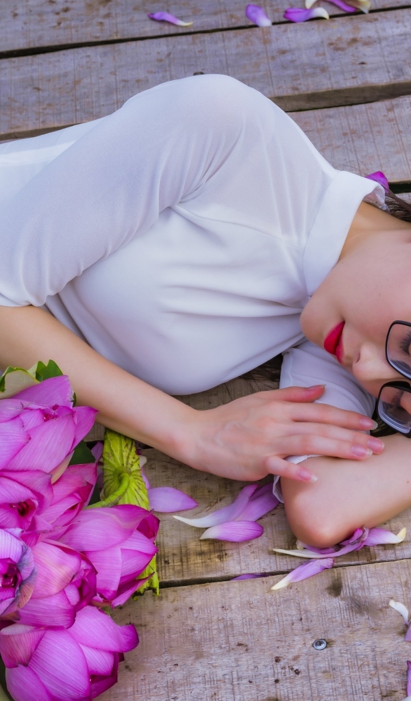 Девушка азиатка лежит с цветами лотоса