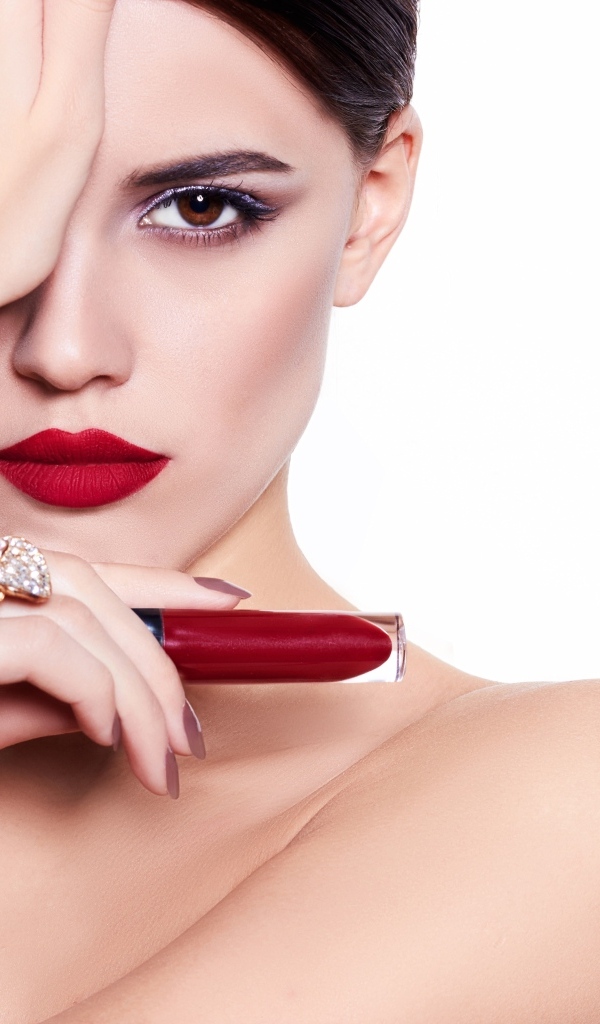 Красивая девушка с красной губной помадой в руке