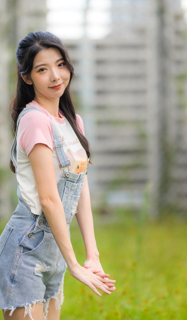 Милая девушка азиатка в джинсовом комбинезоне