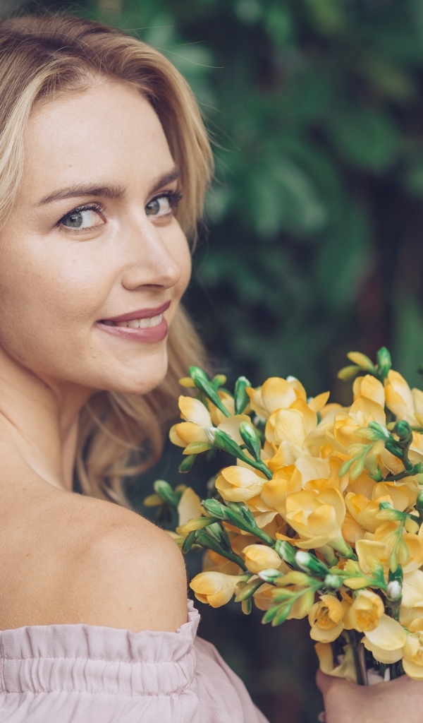 Милая девушка с букетом желтых цветов в руках