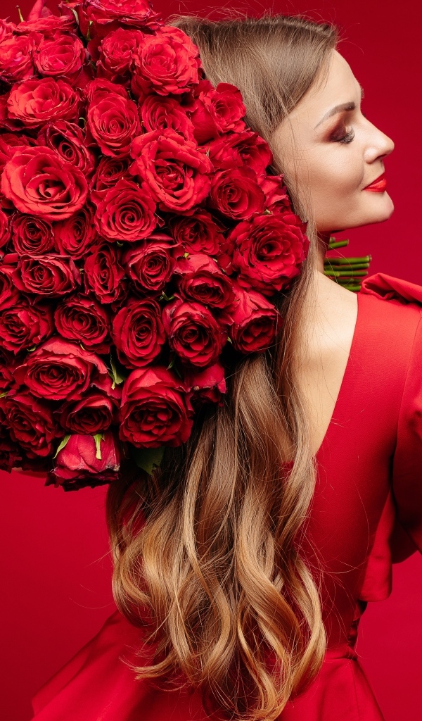 Девушка в красном платье с большим букетом роз