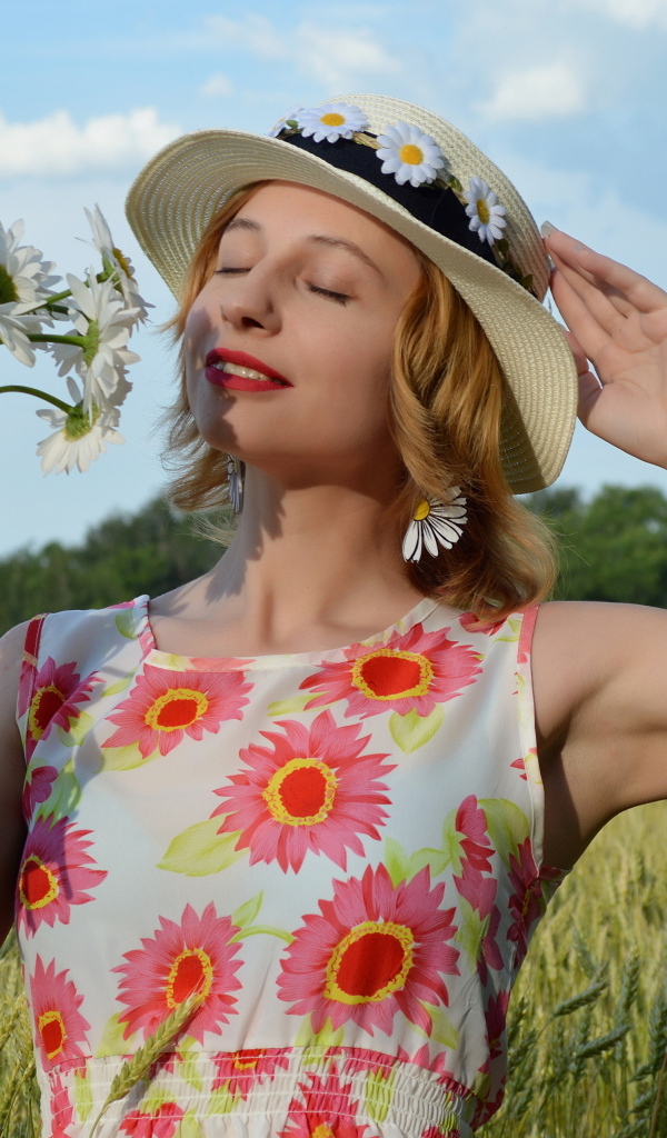 Девушка с букетом ромашек на поле