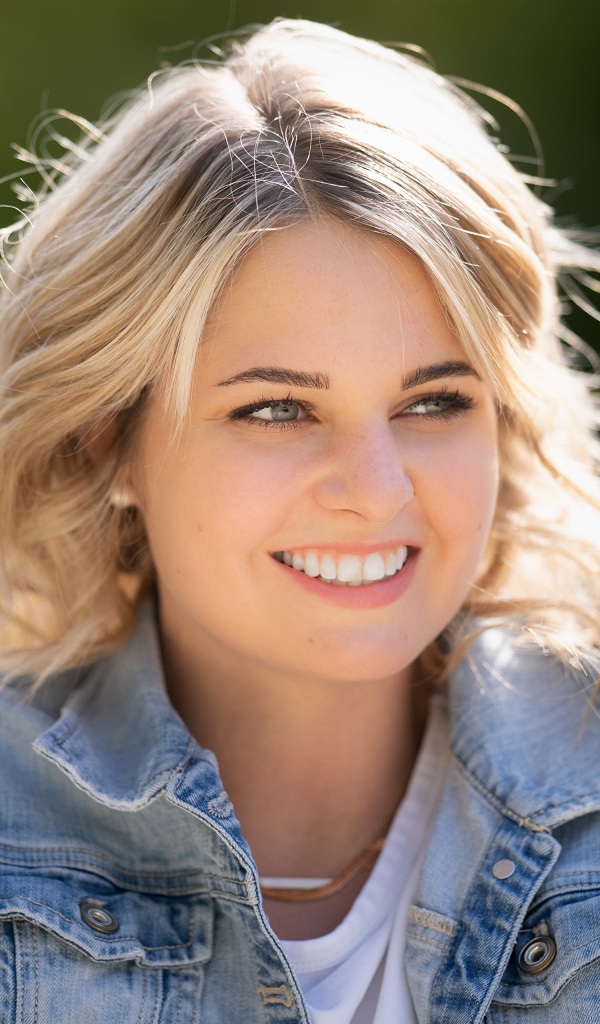 Улыбающаяся блондинка с красивыми белыми зубами