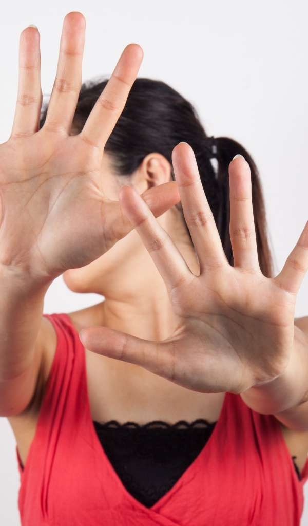 Девушка закрывает лицо руками