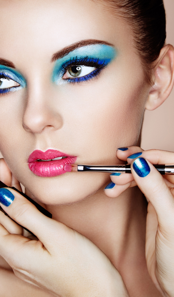 Девушке делают красивый яркий макияж