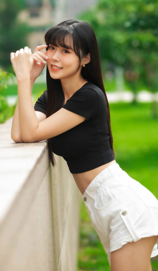 Молодая азиатка в белых шортах и футболке