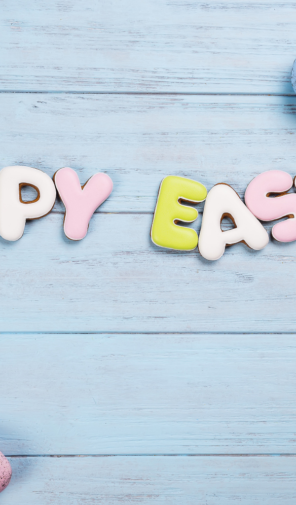 Печенье с надписью счастливой Пасхи с яйцами и цветами