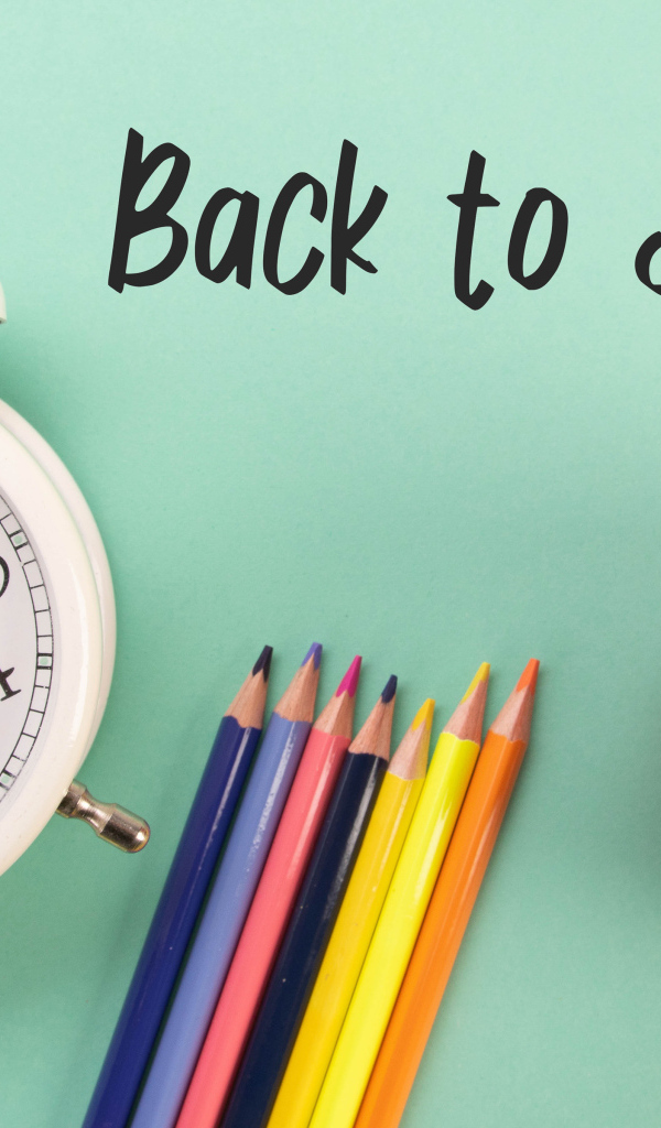 Будильник, карандаши и яблоко на фоне с надписью пора в школу