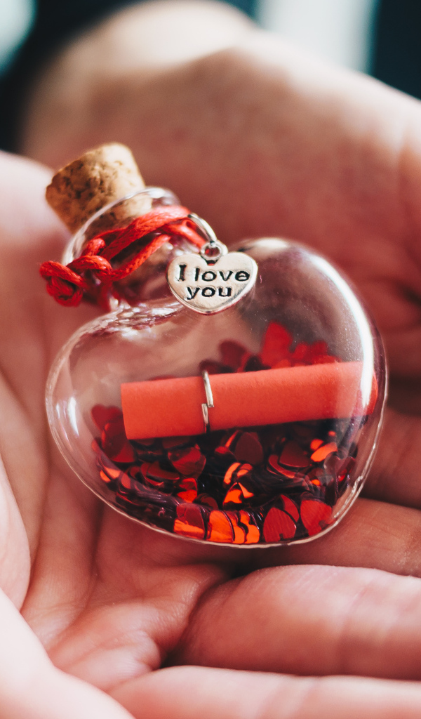 Ладони с маленький стеклянным сердечком
