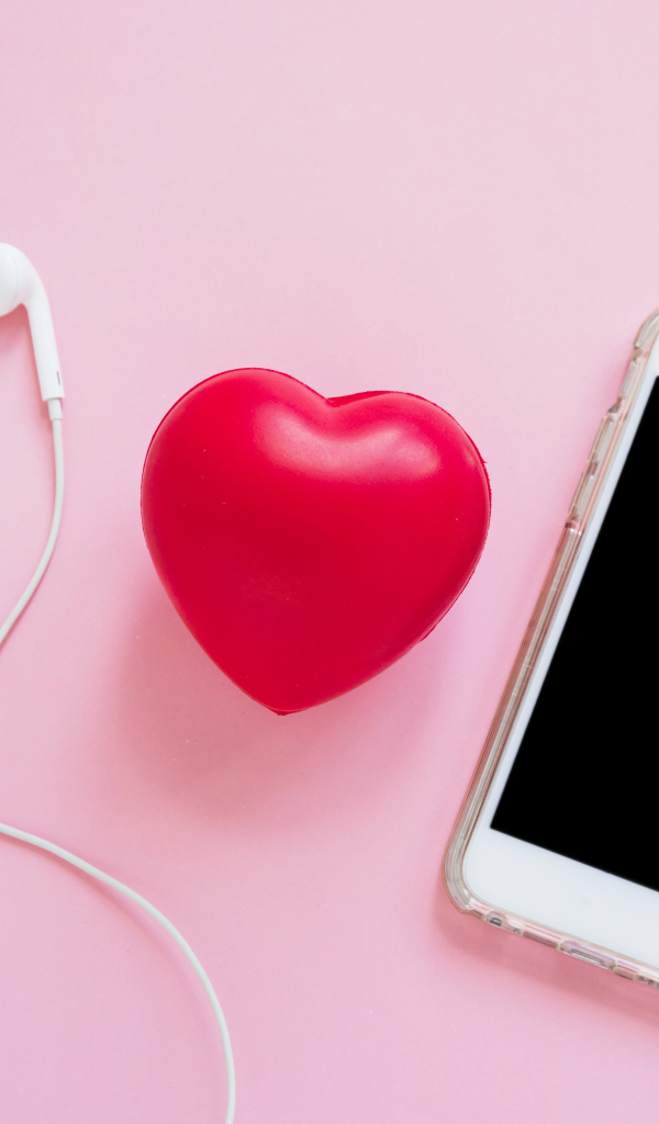 Телефон, наушники и красное сердце на розовом фоне
