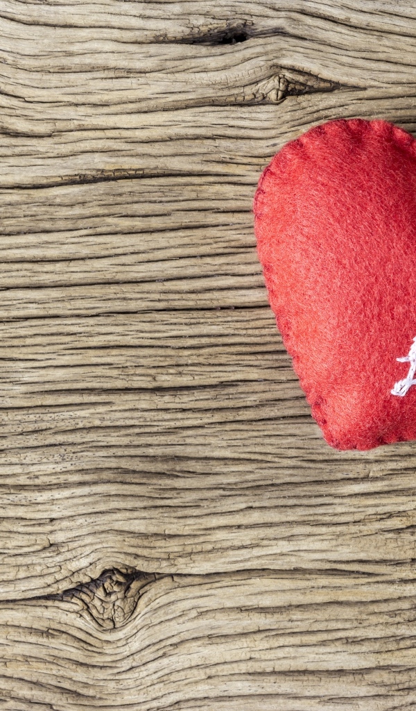 Красное тканевое сердце с цветами на деревянном столе