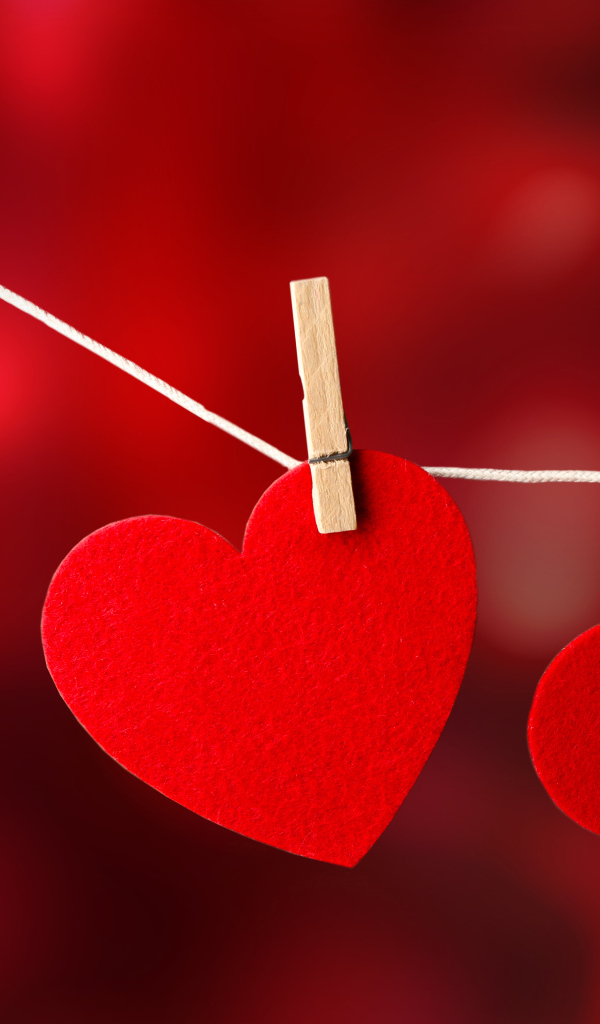Два красных сердца висят на веревке
