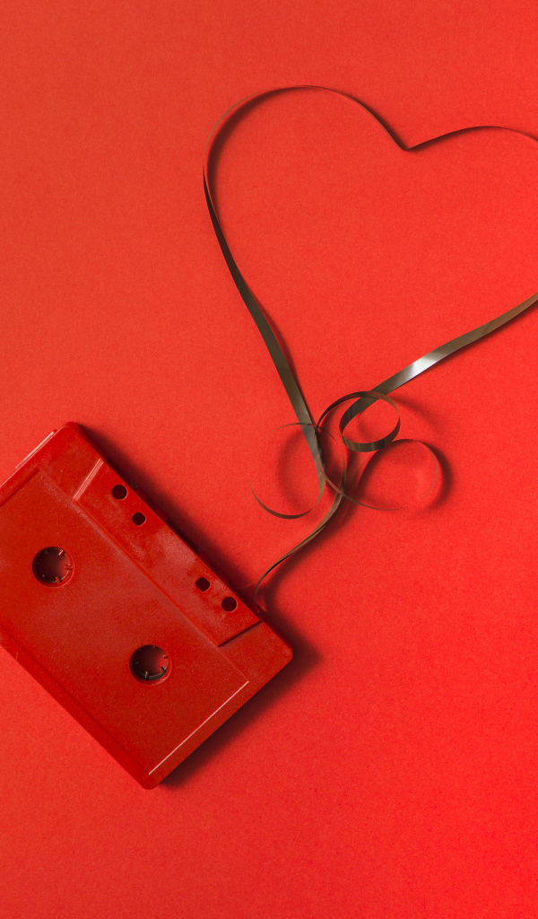 Кассета с сердцем из ленты на красном фоне