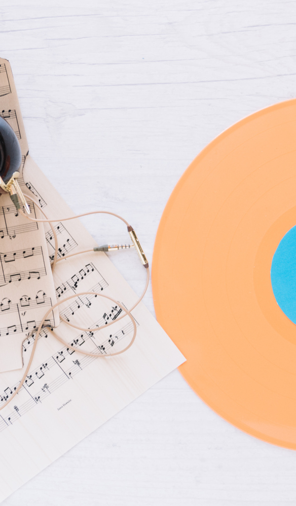 Наушники, ноты и виниловая пластинка на белом фоне