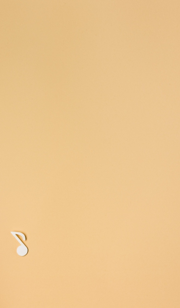 Маленькая гитара с нотами на бежевом фоне