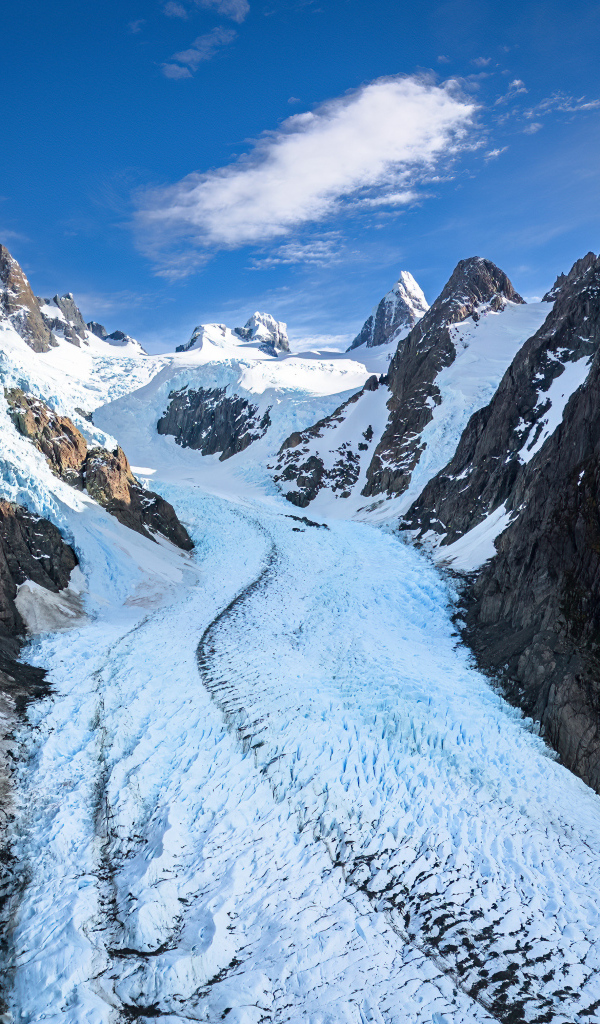 Заснеженная заледеневшая дорога между гор